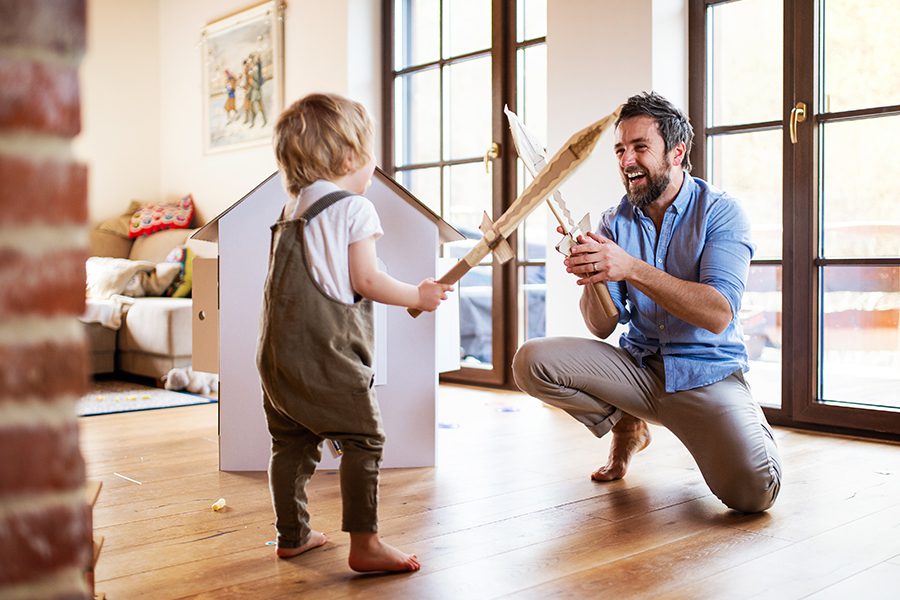Blog - A Young Boy and Father with Cardboard Swords Playing Indoors at Home