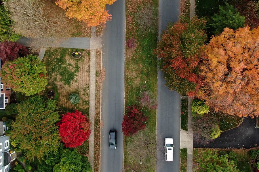 Ligonier, Pa - Suburban Residential Area with Two Lane Road Aligned with Colorful Trees in Autumn Foliage in Neighborhood with Aerial View